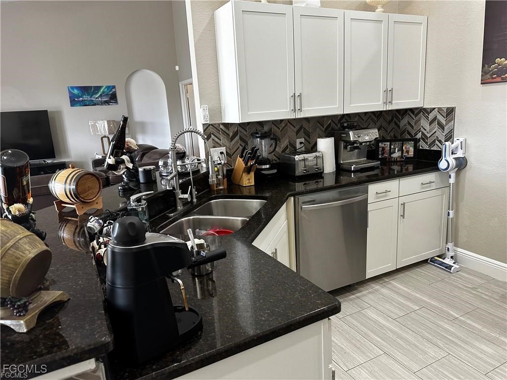 3315 37th Street Southwest Lehigh Acres, FL 33976 - Photo 17 of 34 a kitchen with stainless steel appliances granite countertop a sink dishwasher a stove a dining table and chairs with wooden floor
