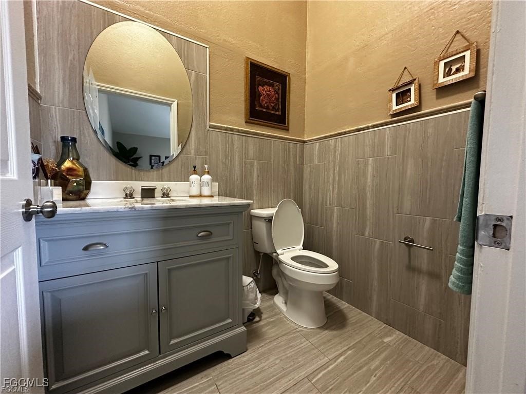 3315 37th Street Southwest Lehigh Acres, FL 33976 - Photo 22 of 34 a bathroom with a toilet sink and mirror