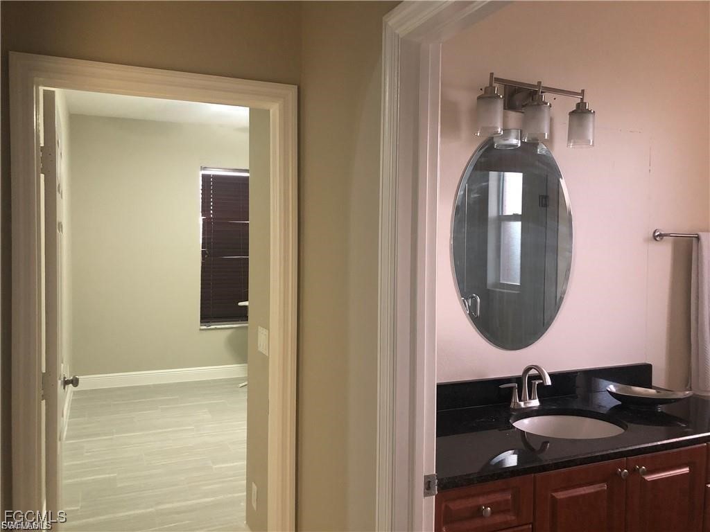3315 37th Street Southwest Lehigh Acres, FL 33976 - Photo 28 of 34 a bathroom with a sink and a mirror