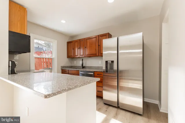 a kitchen with stainless steel appliances granite countertop a refrigerator a sink and a stove
