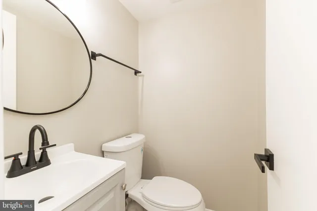 a bathroom with a sink a toilet and a mirror