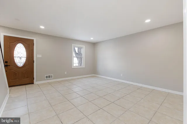 an empty room with mirror and windows