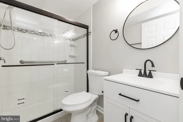 a bathroom with a sink a toilet and a mirror