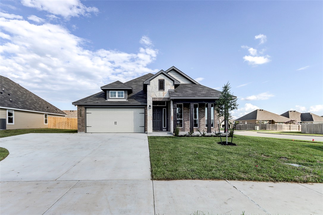 a front view of a house with a garden and yard