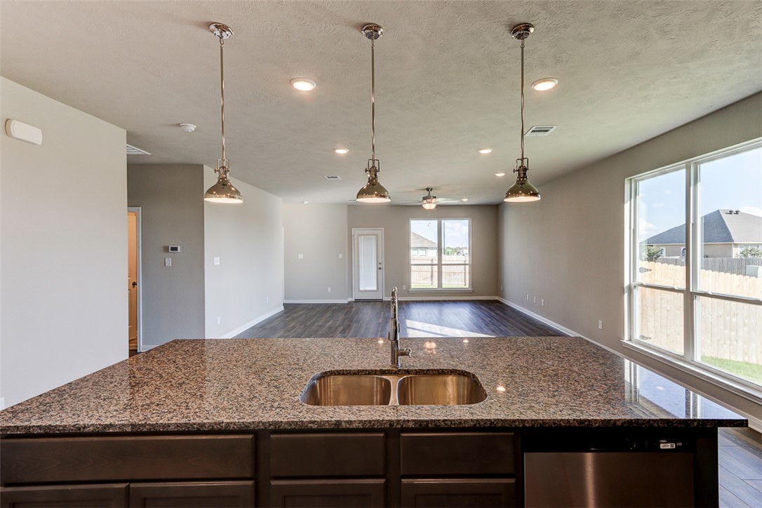 1937 Viva Road Bryan, TX 77807 - Photo 10 of 25 a kitchen with kitchen island a sink stainless steel appliances and a window