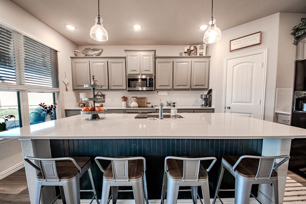150 Oak Grove Drive Rhome, TX 76078 - Photo 12 of 40 a kitchen with a dining table chairs cabinets and stainless steel appliances