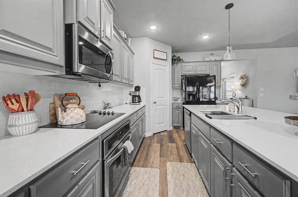 150 Oak Grove Drive Rhome, TX 76078 - Photo 15 of 40 a kitchen with stainless steel appliances granite countertop a sink and stove top oven