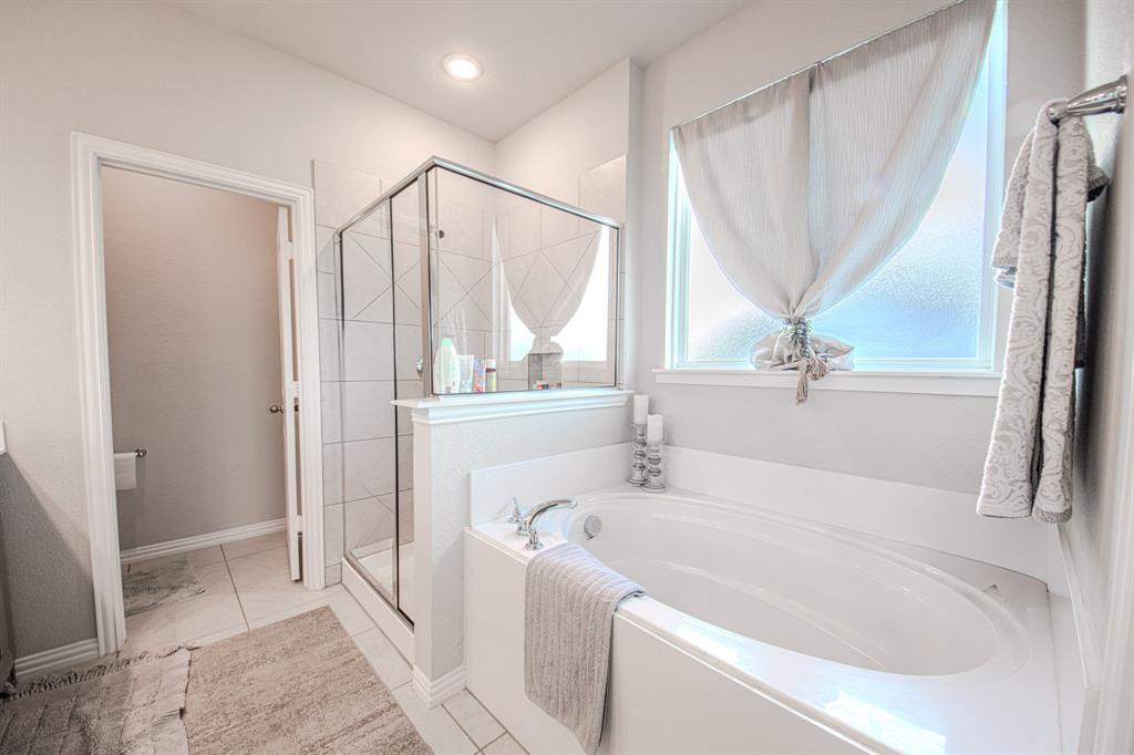 150 Oak Grove Drive Rhome, TX 76078 - Photo 20 of 40 a bathroom with a tub a sink and a large mirror