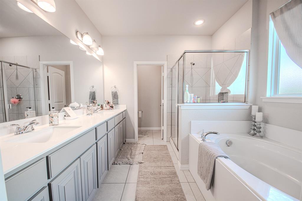 150 Oak Grove Drive Rhome, TX 76078 - Photo 21 of 40 a bathroom with a double vanity sink mirror and a bathtub