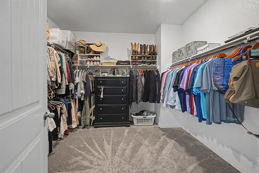 150 Oak Grove Drive Rhome, TX 76078 - Photo 24 of 40 a view of walk in closet with clothes and shoes