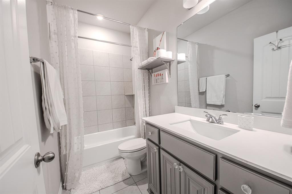 150 Oak Grove Drive Rhome, TX 76078 - Photo 32 of 40 a bathroom with a sink a toilet a mirror and shower