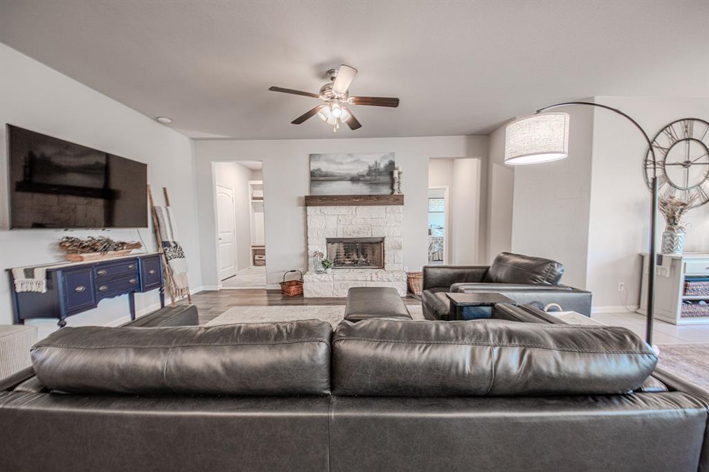 150 Oak Grove Drive Rhome, TX 76078 - Photo 5 of 40 a living room with furniture a flat screen tv and a fireplace