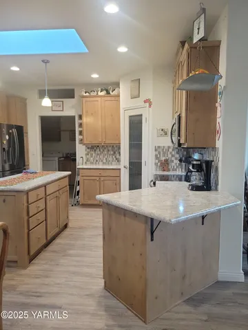 a large kitchen with kitchen island a sink stainless steel appliances and cabinets