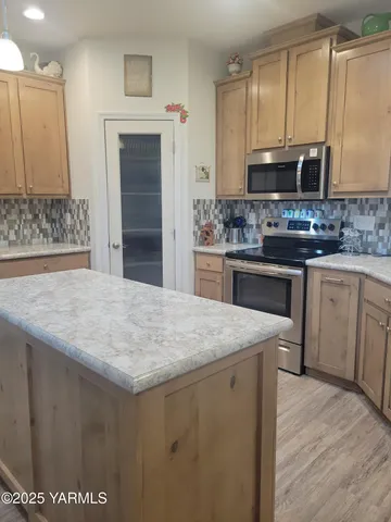 a kitchen with stainless steel appliances granite countertop a sink stove and microwave