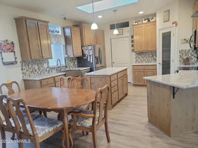 a large kitchen with kitchen island a dining table and chairs