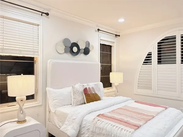 a bedroom with a bed couch and wooden floor
