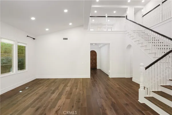 a view of a hallway with wooden floor and staircase