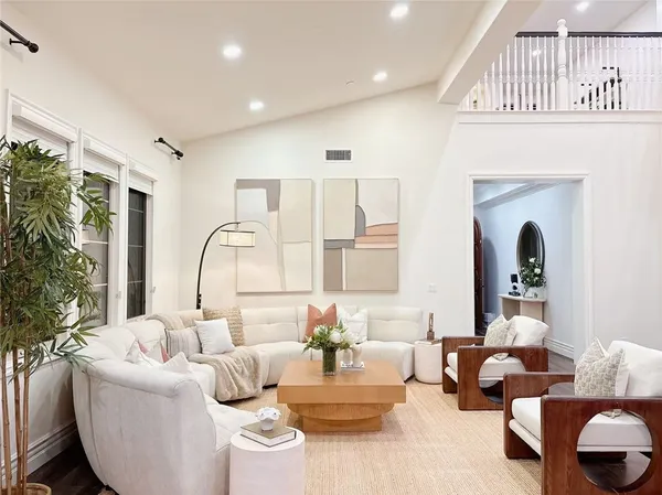 a living room with furniture flowerpot and a chandelier