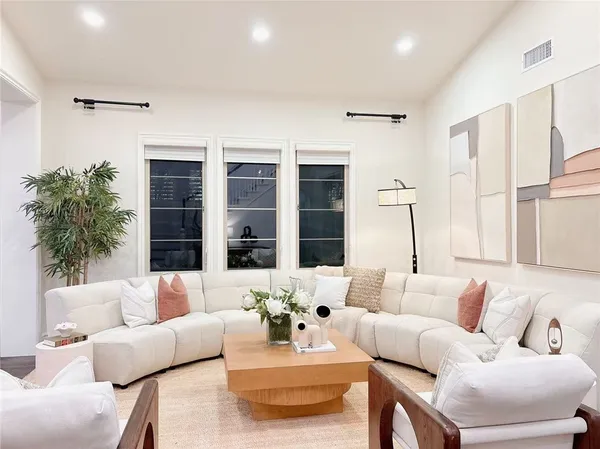 a living room with furniture a fireplace and a large window