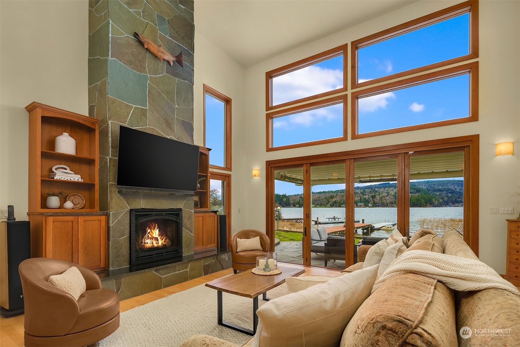 49 Strawberry Point Road Bellingham, WA 98229 - Photo 11 of 40 a living room with furniture a flat screen tv and a fireplace