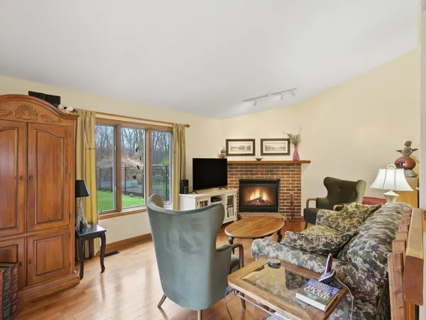 a living room with furniture a fireplace and a floor to ceiling window