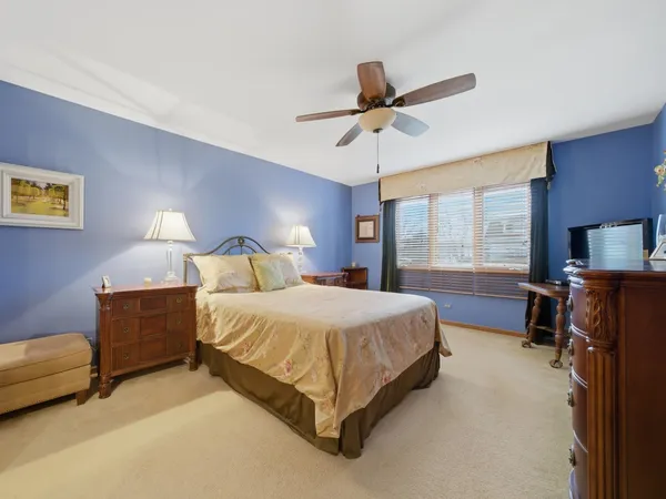 a spacious bedroom with a bed and a chandelier