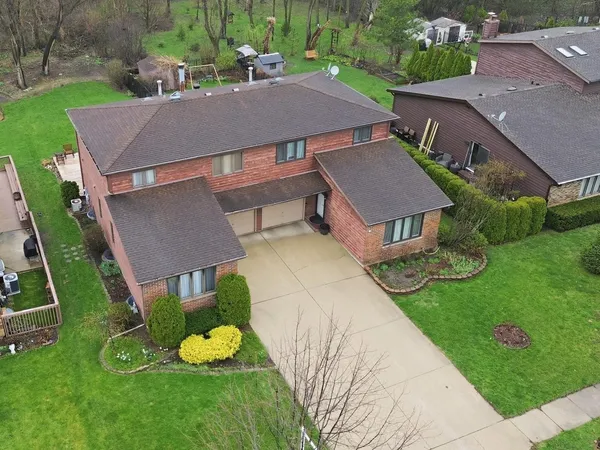 an aerial view of a house with garden space and street view