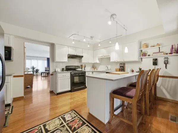 a kitchen with a table chairs refrigerator and cabinets