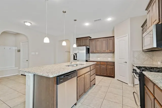 a kitchen with a stove a sink and a refrigerator