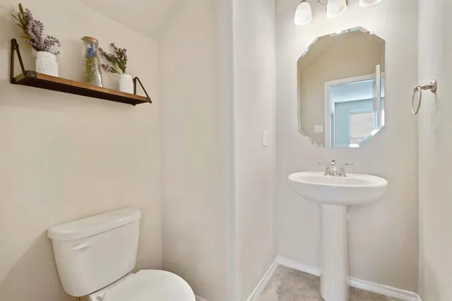 a bathroom with a toilet a sink and mirror