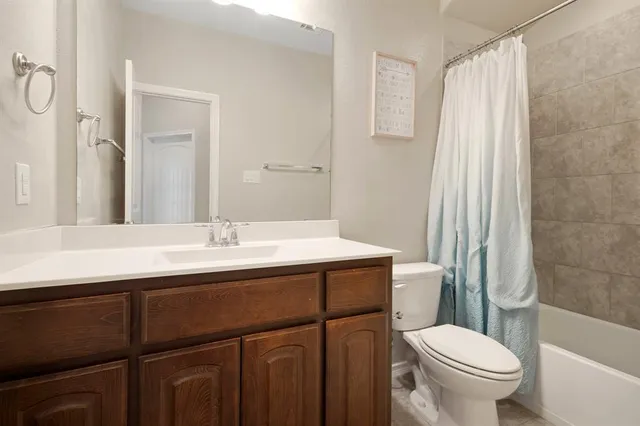 a bathroom with a sink a toilet a mirror and shower curtain