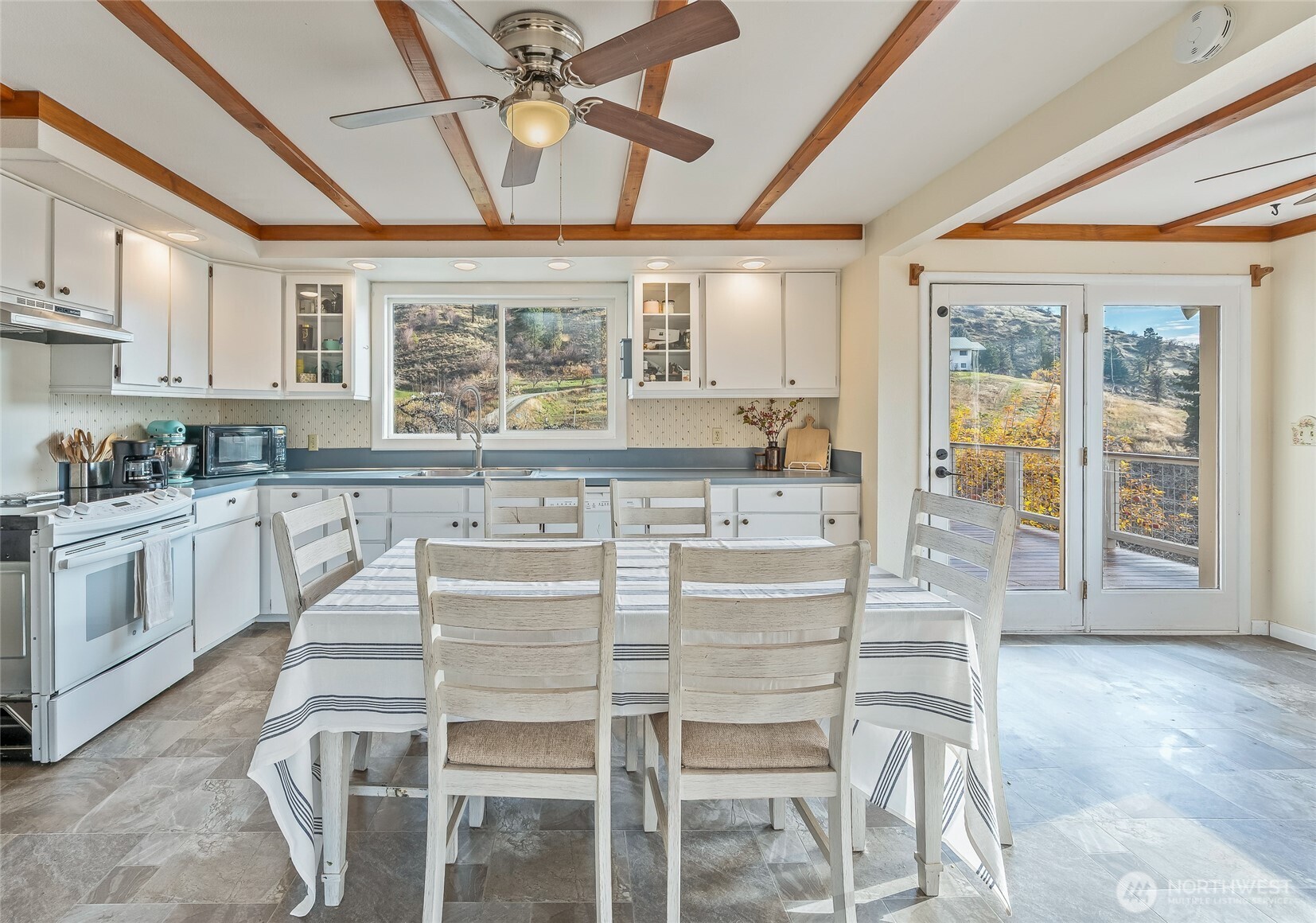 8133 North Dryden Road Cashmere, WA 98815 - Photo 12 of 36 a kitchen with granite countertop a stove a table and chairs with wooden floor
