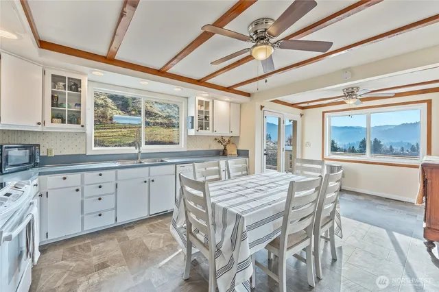 a kitchen with granite countertop a sink dining table and chairs