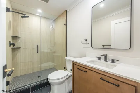 a bathroom with a sink a toilet and shower