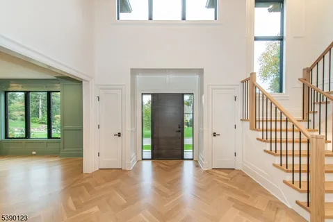 a view of a hallway with wooden floor and a living room