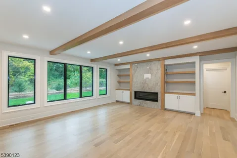 a view of an empty room with a fireplace and a window