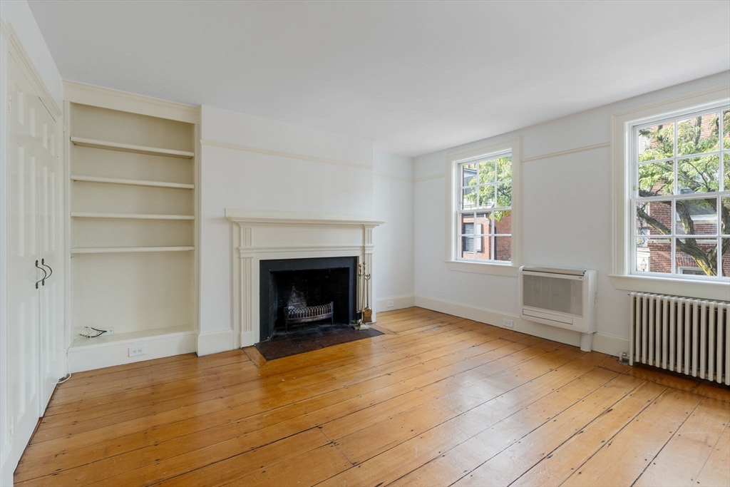 24 Fayette Street, Unit 24 Boston, MA 02116 - Photo 13 of 36 a view of an empty room with wooden floor fireplace and a window