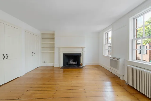 a view of an empty room with a window and fireplace