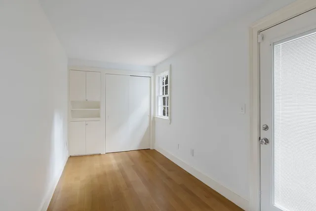 a view of a small space with wooden floor and a window