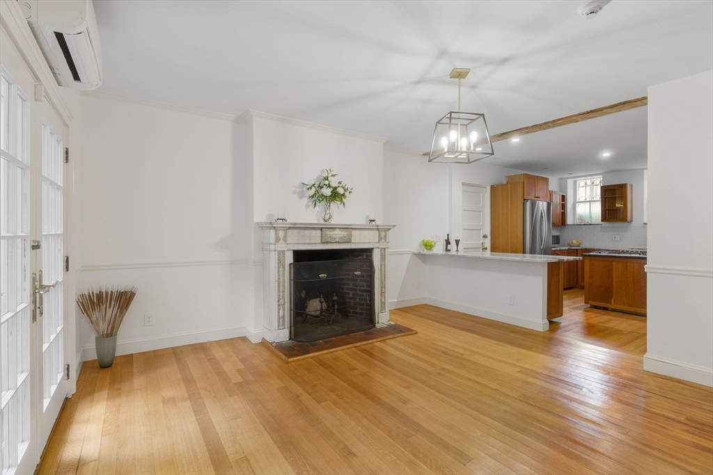 24 Fayette Street, Unit 24 Boston, MA 02116 - Photo 30 of 36 a view of a livingroom with a fireplace a chandelier and wooden floor