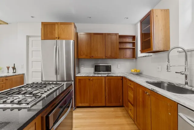 a kitchen with stainless steel appliances granite countertop a stove a sink dishwasher and a refrigerator