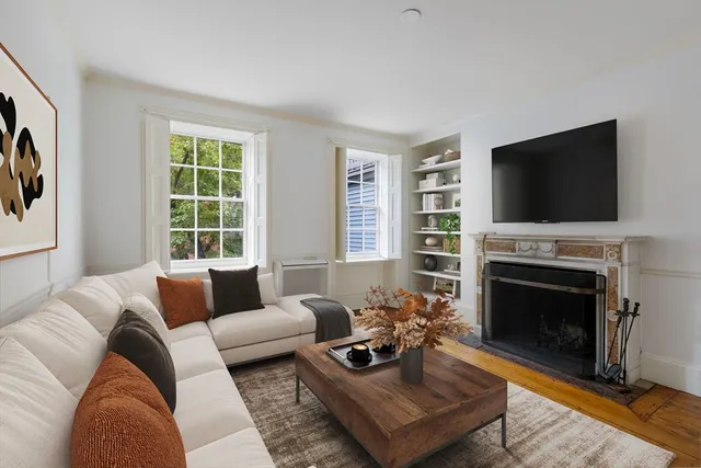 a living room with furniture a flat screen tv and a fireplace
