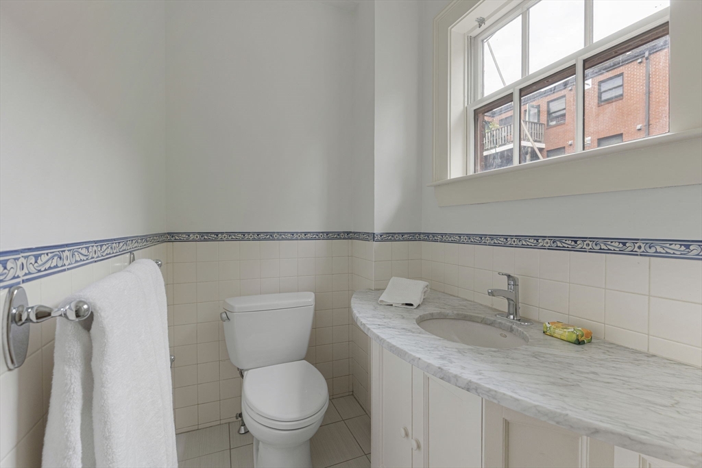 24 Fayette Street, Unit 24 Boston, MA 02116 - Photo 10 of 36 a bathroom with a granite countertop toilet and a sink