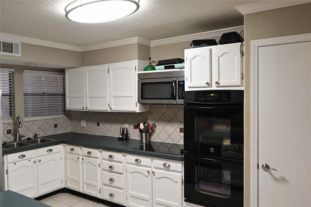 32 Rue Maison Abilene, TX 79605 - Photo 11 of 40 a kitchen with granite countertop white cabinets and black appliances