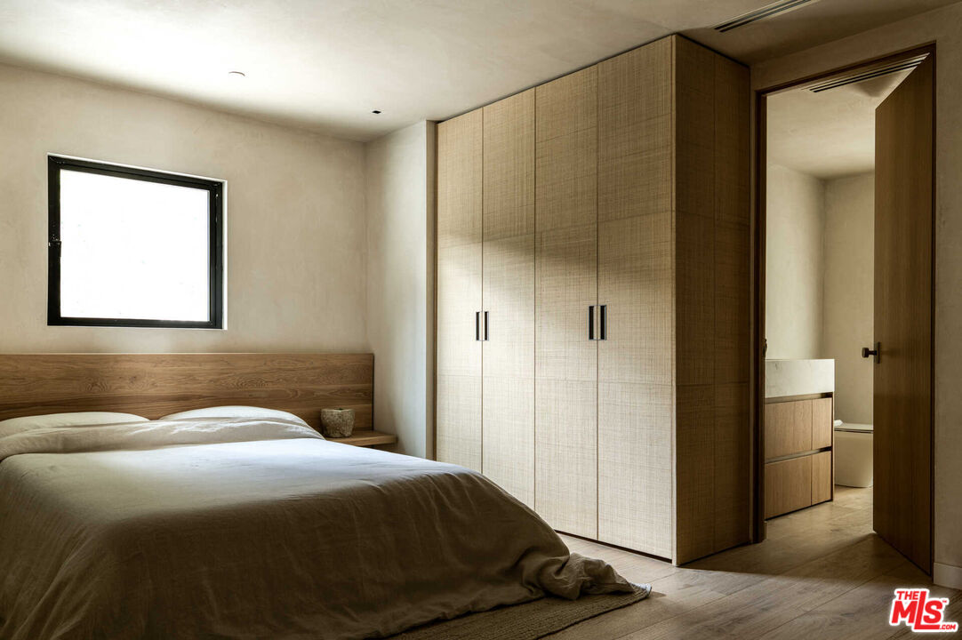 1718 Rising Glen Road Los Angeles, CA 90069 - Photo 11 of 19 a bedroom with a bed and a mirror