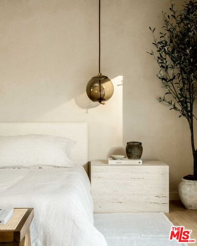 a bedroom with a bed and a potted plant