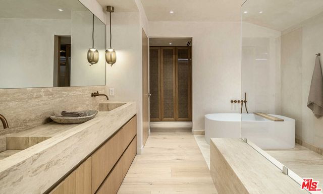 a spacious bathroom with a granite countertop sink and a bathtub