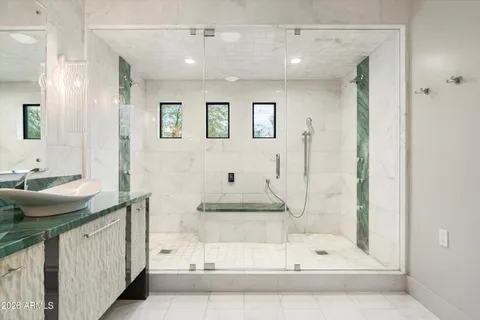 a bathroom with a glass shower door and mirror