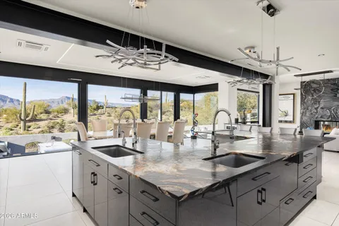 a kitchen with stainless steel appliances granite countertop a sink and a refrigerator