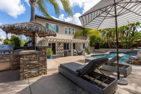 a view of a house with backyard and sitting area